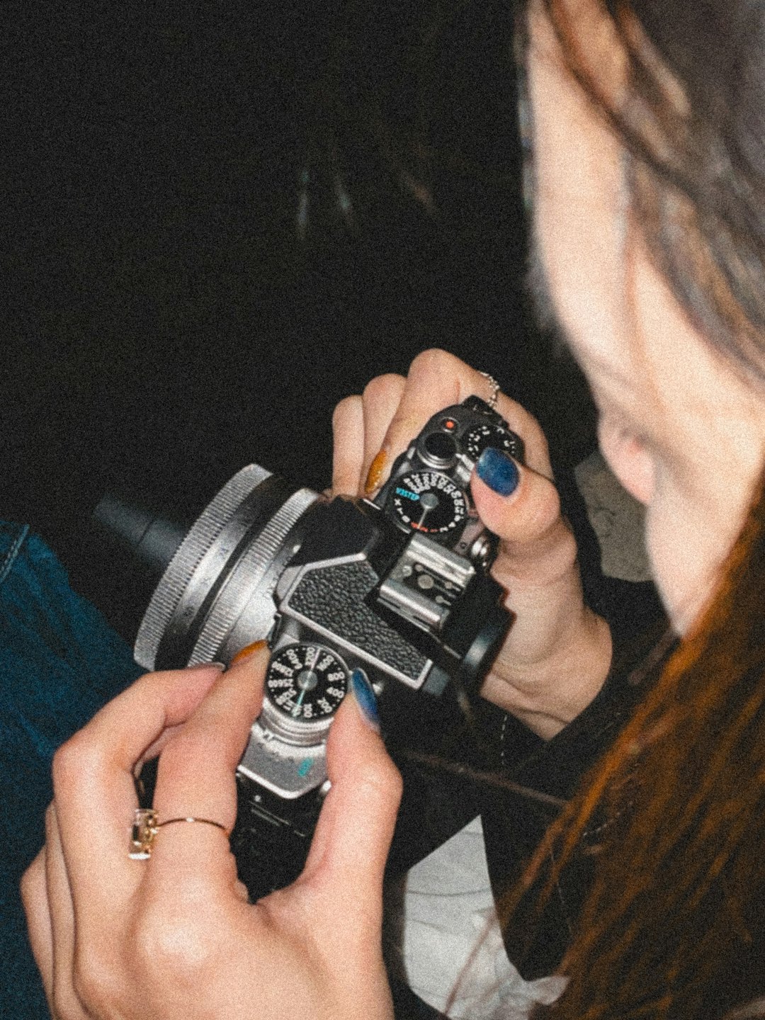 Dłonie regulujące ustawienia starego aparatu.